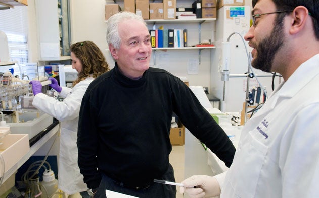 Ken Kellar, professor of pharmacology, speaks with a graduate student in a science lab.