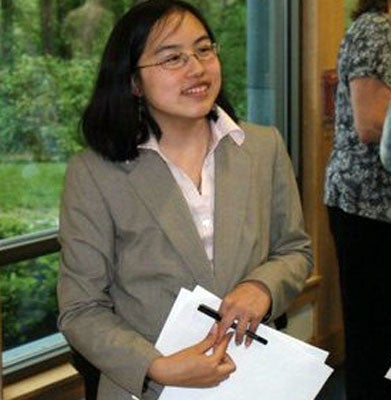 Lydia Brown stands holding papers