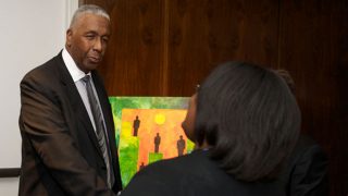 John Thompson Jr. speaks with a woman at a local Boys &amp; Girls Club.