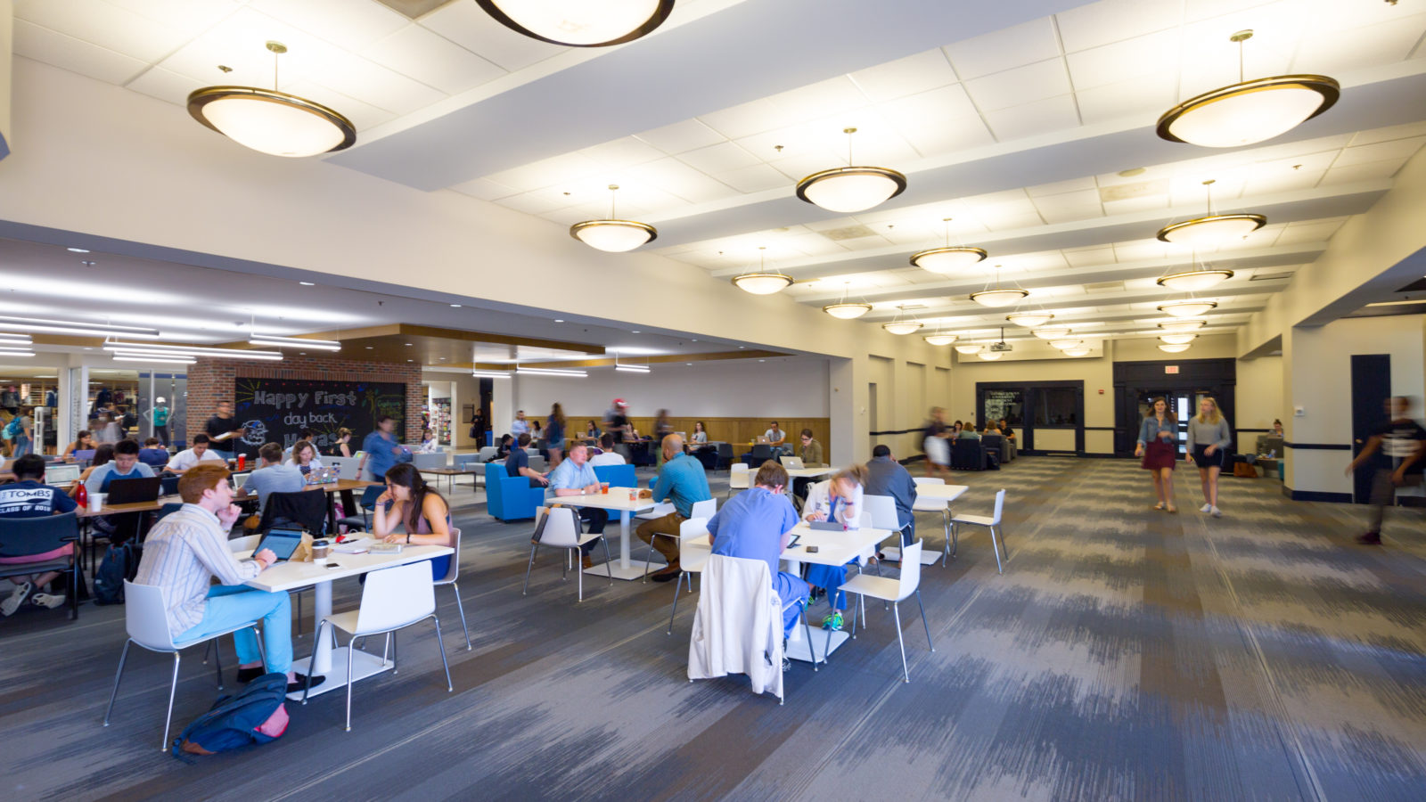 Students are pictured studying in the Leavey Center at different tables.