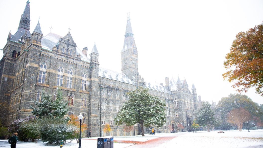 Snow falling around Healy Hall.