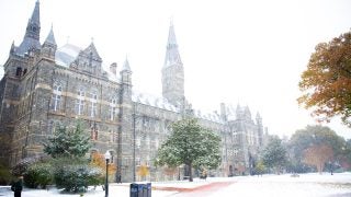 Snow falling around Healy Hall.