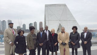 Descendants and other members of the Georgetown community stand before a sculpture at the United Nations in New York