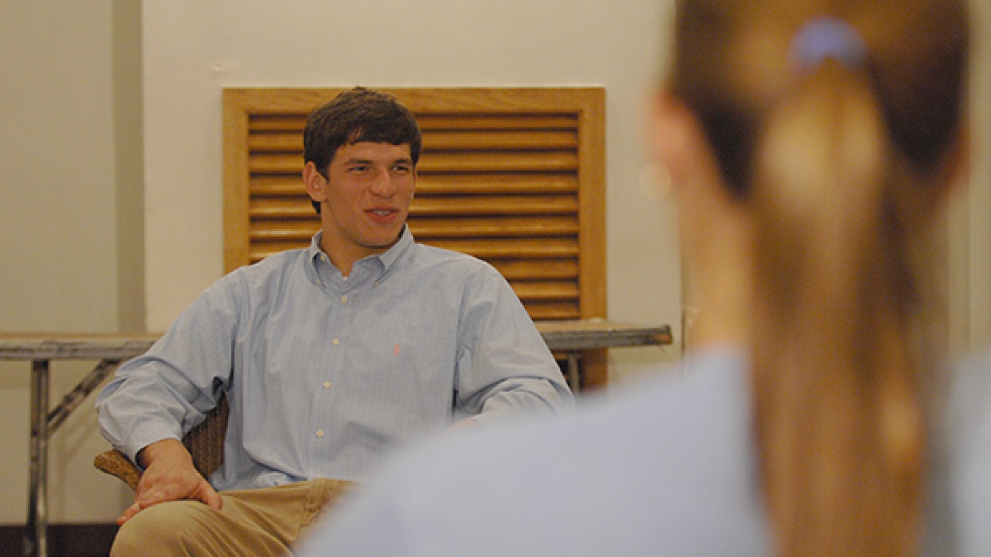 Dr. David C. Fajgenbaum sitting in a chair talking to a woman