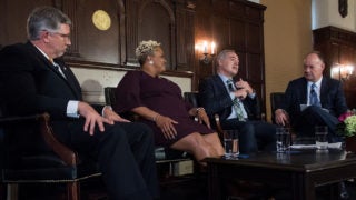 Panelists Scott Rall, DeRionne Pollard and Ángel Cabrera talk to one another seated during a discussion in Copley Formal Lounge.