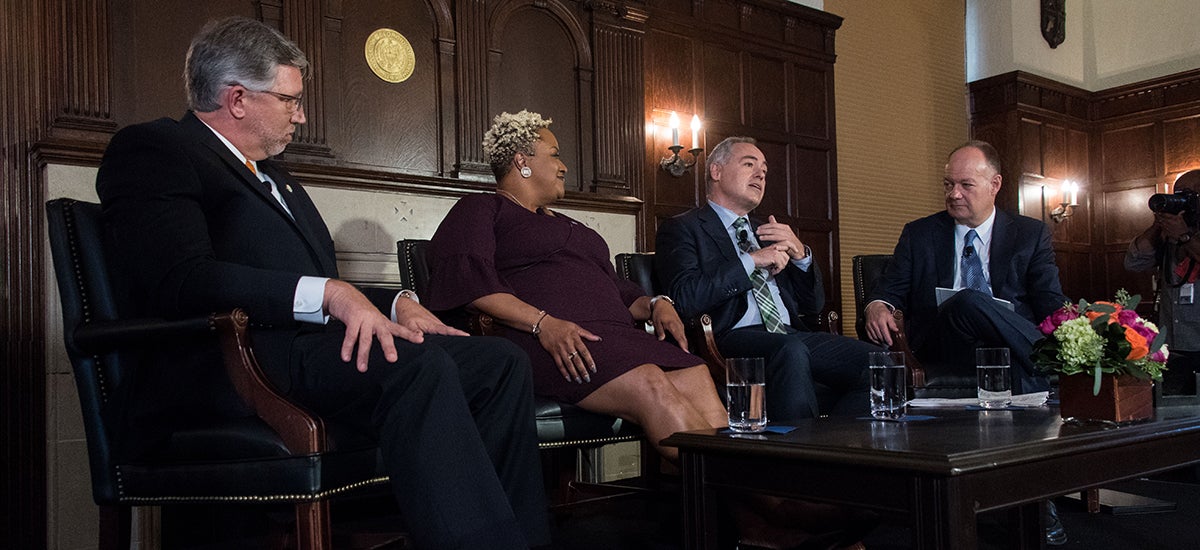 Panelists Scott Rall, DeRionne Pollard and Ángel Cabrera talk to one another seated during a discussion in Copley Formal Lounge.