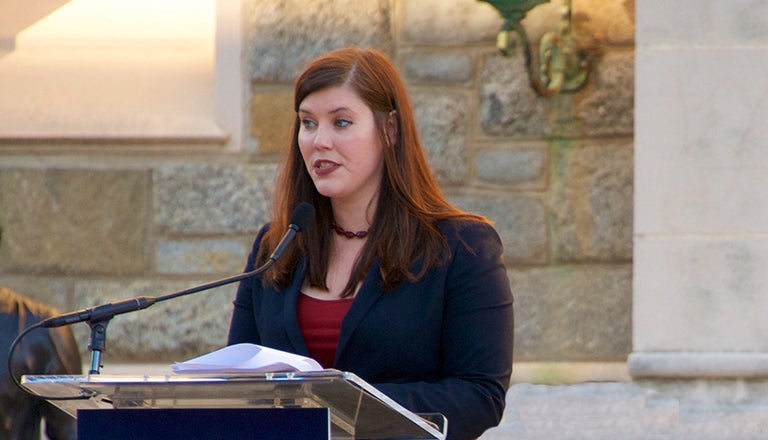 U.S. Marine veteran Cristine Pedersen speaks into a microphone.