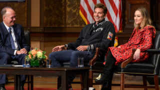 Georgetown President John J. DeGioia sits and talks to Bradley Cooper and Blair Rich on stage in Gaston Hall.