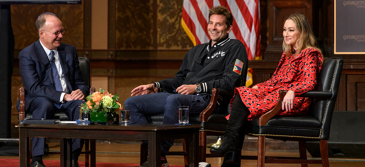 Georgetown President John J. DeGioia sits and talks to Bradley Cooper and Blair Rich on stage in Gaston Hall.
