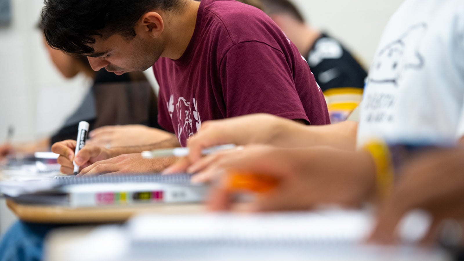 A student leans over his notebook in a Georgetown classroom