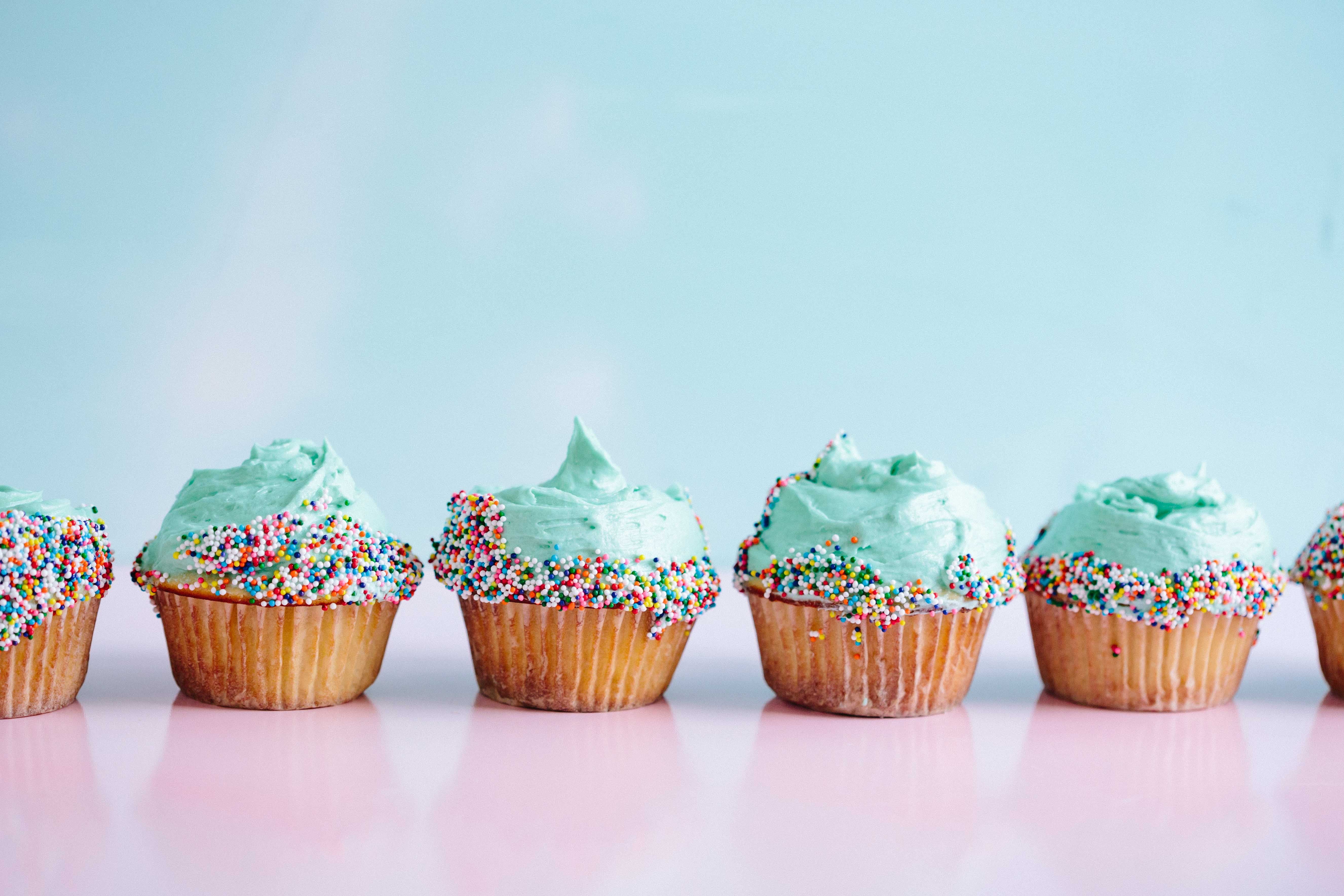 Cupcakes in a line on a table.
