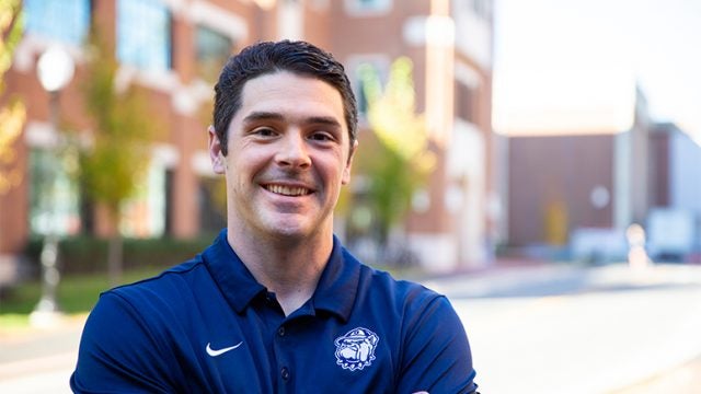 Sean Cooke outside with buildings behind him