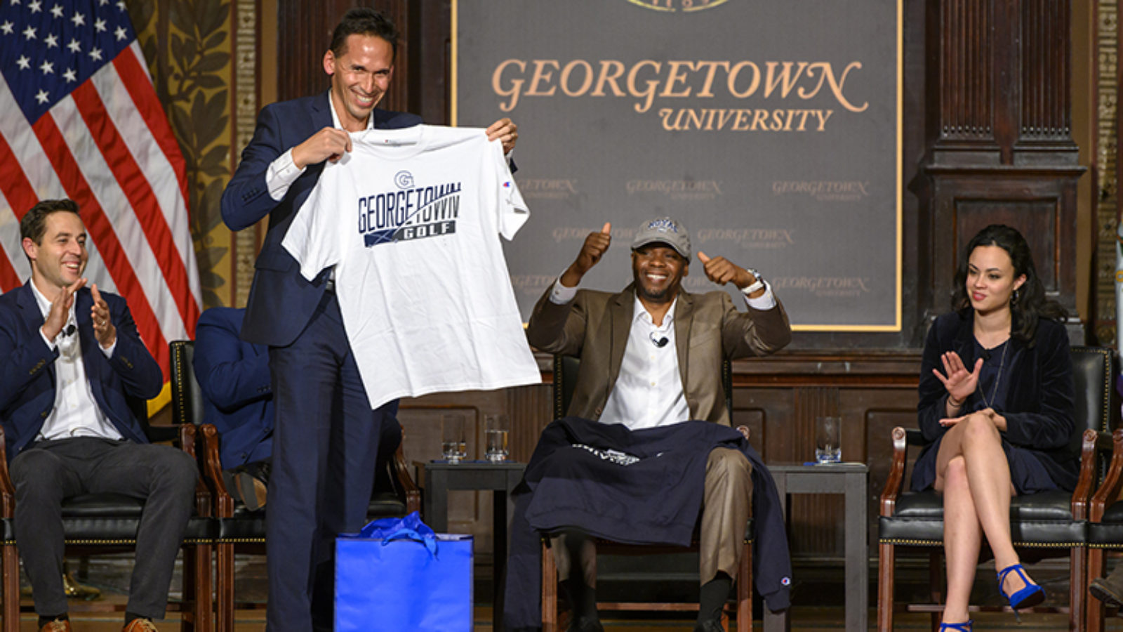 Marc Howard holds up Georgetown T-shirt as Valentino Dixon raises hands