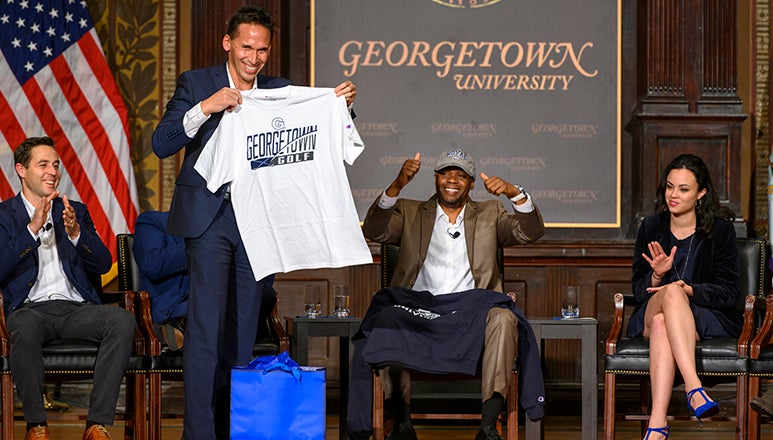 Marc Howard holds up Georgetown T-shirt as Valentino Dixon raises hands