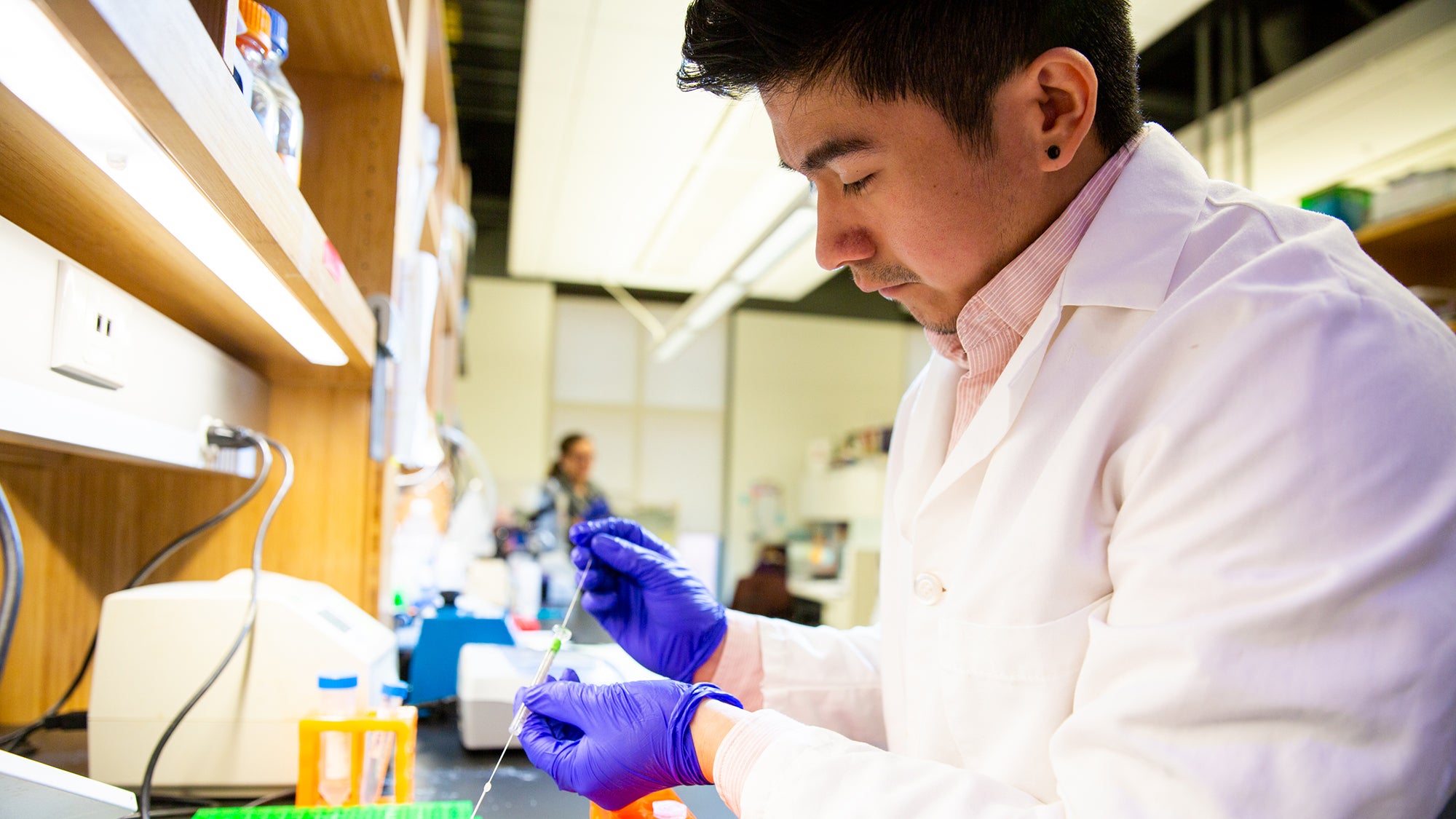 George Melchor takes a sample while working in the laboratory.