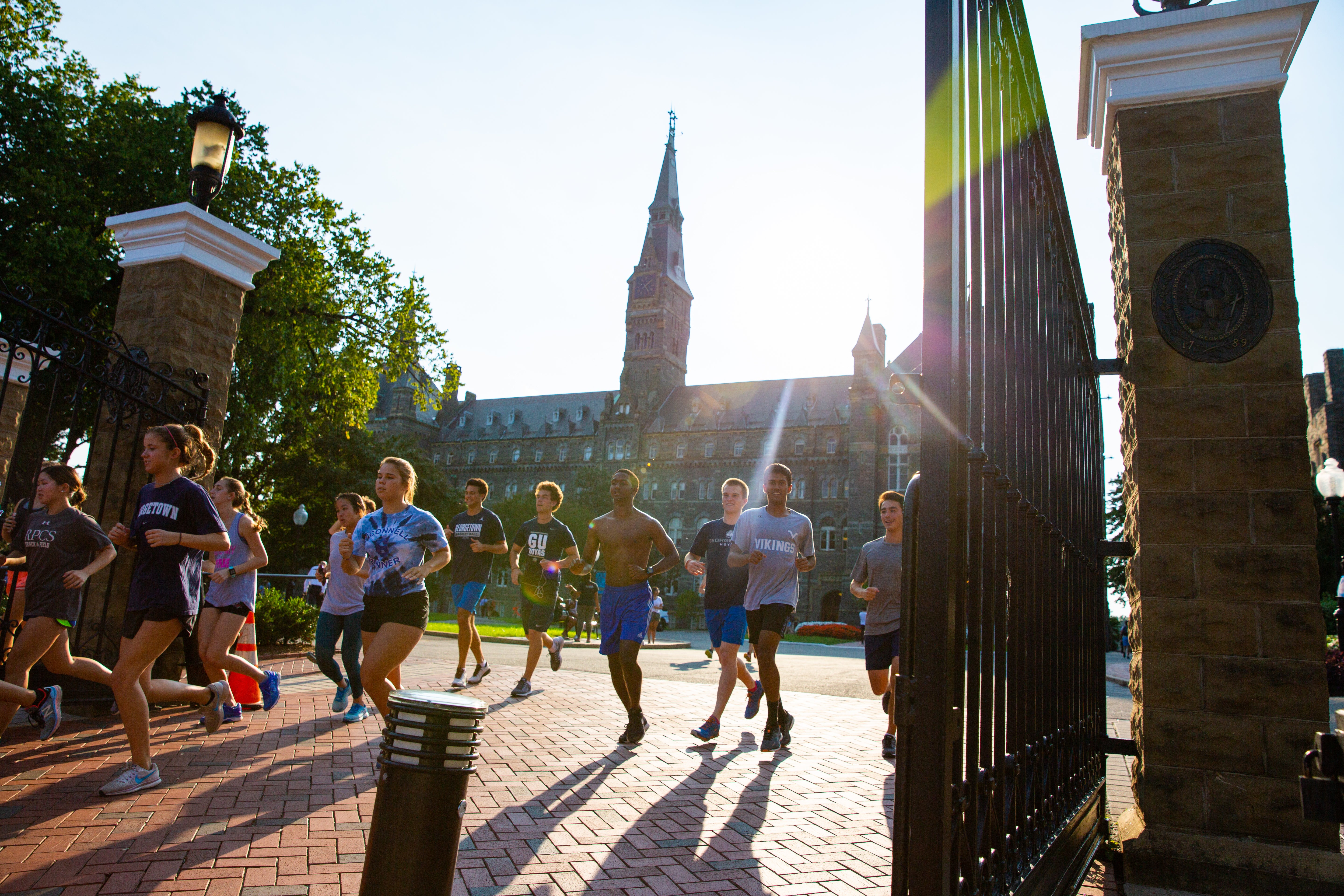 Runners run through Georgetown's front gates.