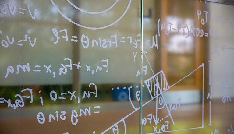 Mathematical functions written on a whiteboard.