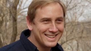 Peter Marra outside with trees behind him