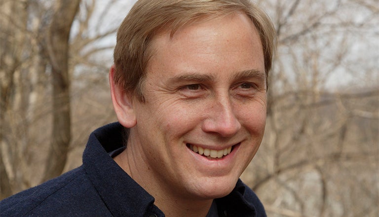 Peter Marra outside with trees behind him