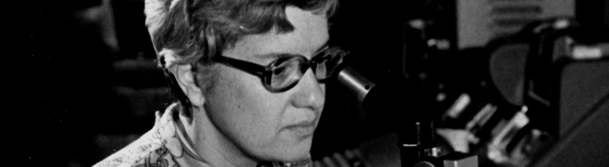 Vera Rubin looks into a microscope