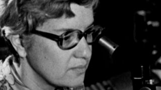 Vera Rubin looks into a microscope