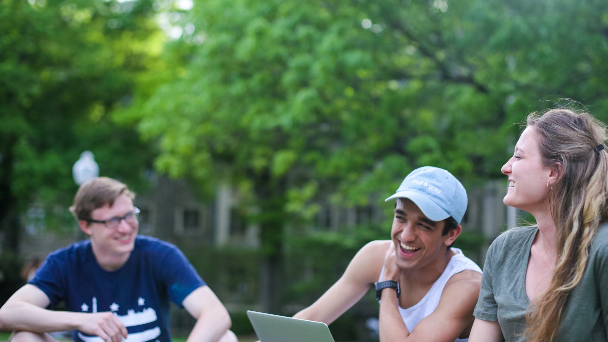 Students sit in groups on the grass outside of Healy Hall.