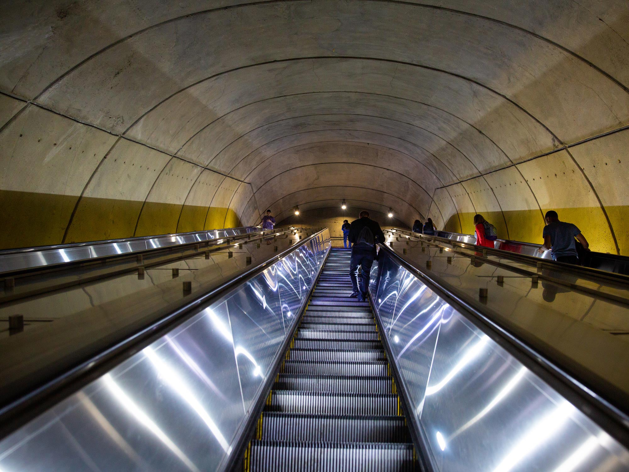 A person heads down an escalator to the Metro trains.