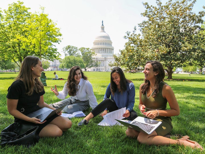 Students sit on the lawn out side the Capitol