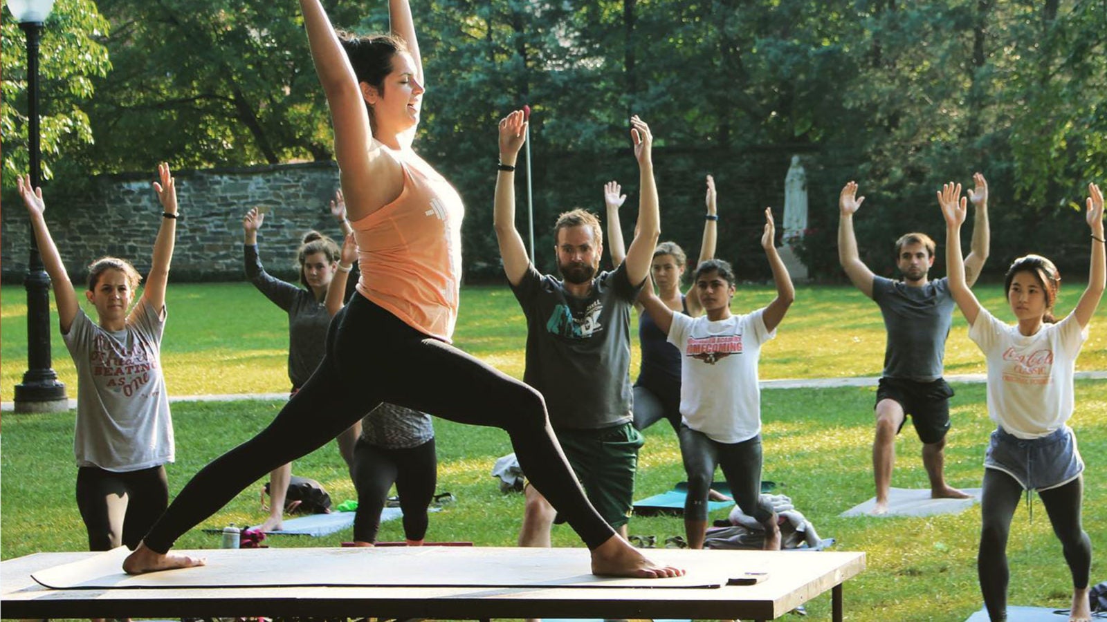 A group performs yoga on Georgetown&#039;s front lawn.