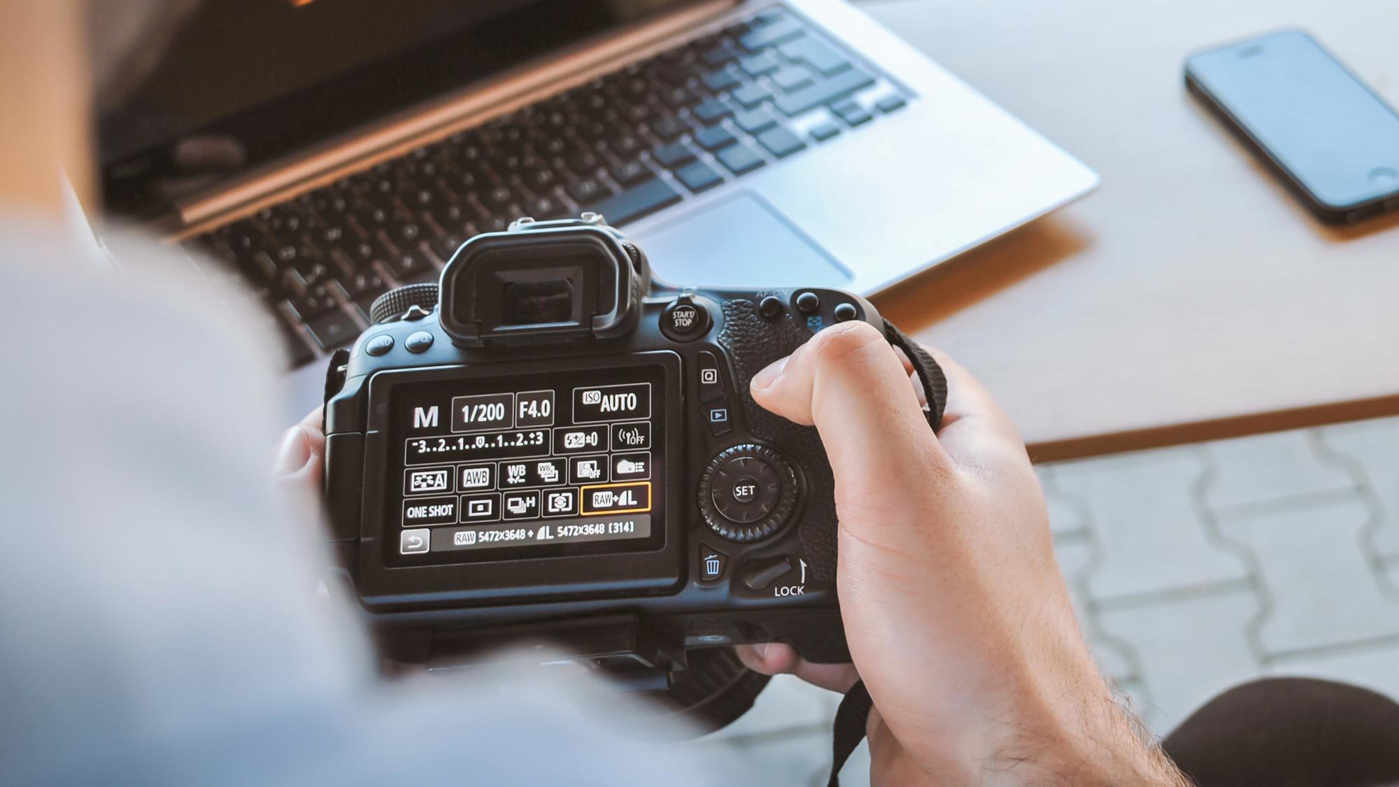 A man looks at the display on his camera.