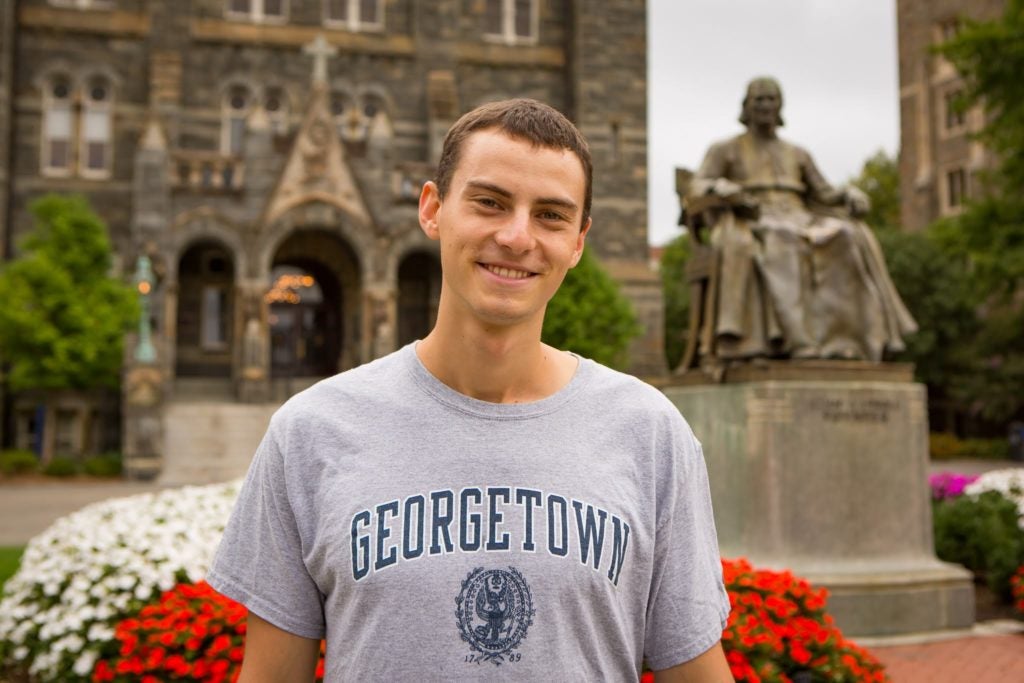 Jacob Werden stands in front of Healy Hall.