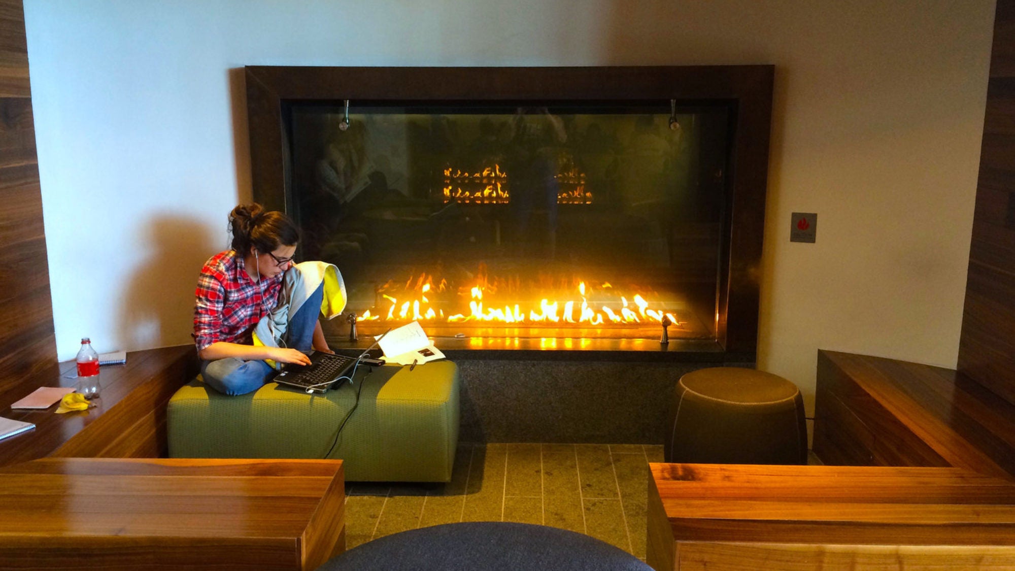 A student works near the fireplace in the Healey Family Student Center