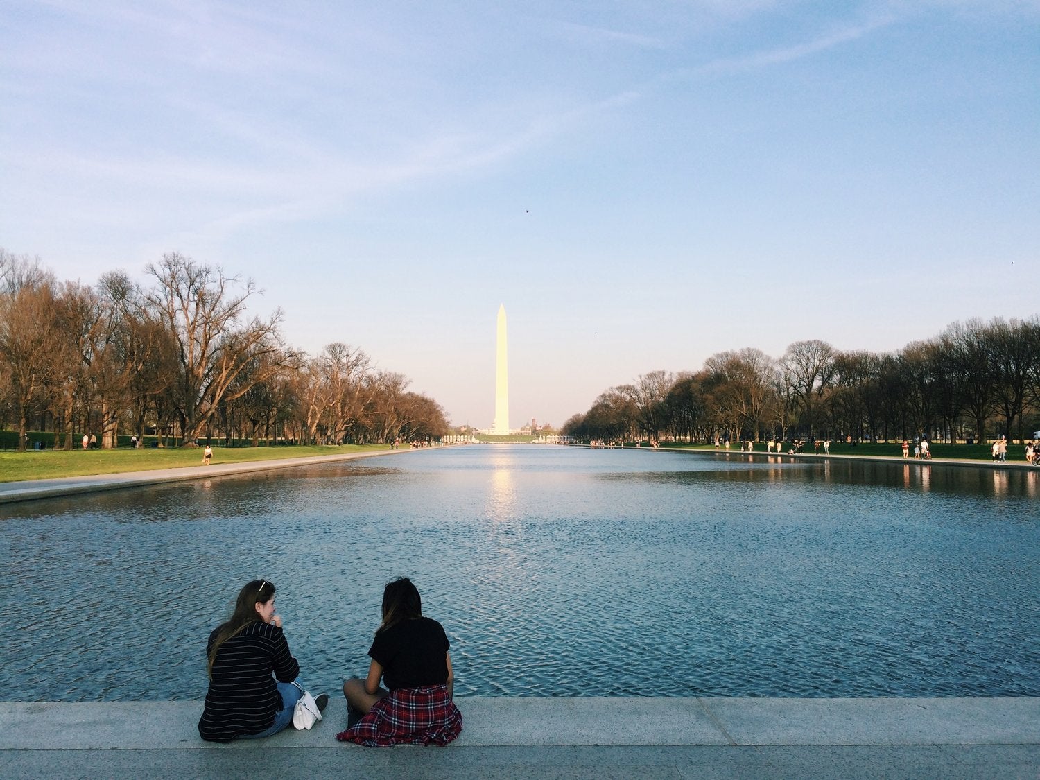 Students sit near the reflecting pool