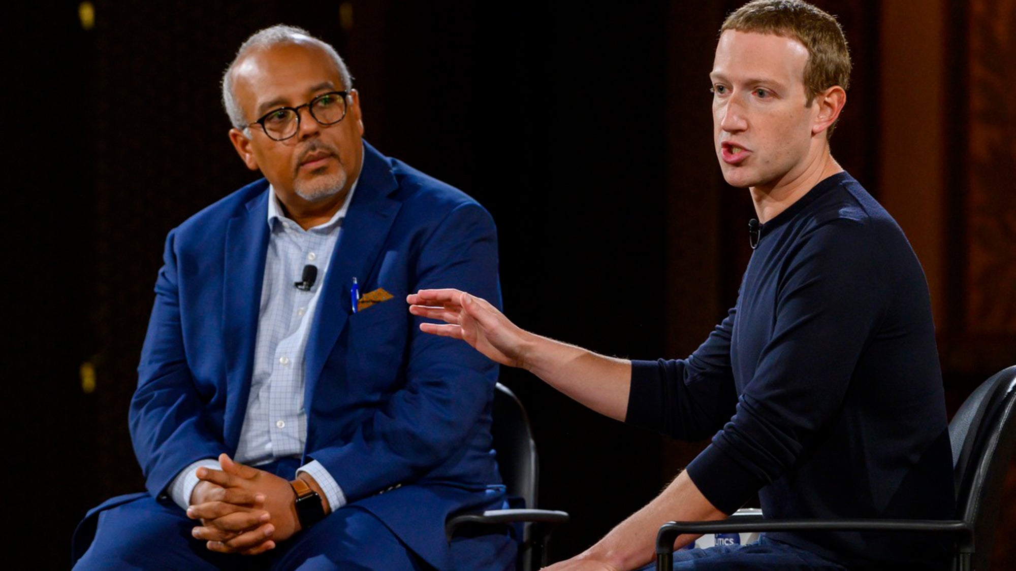 Mo Elleithee and Maerk Zuckerberg talk while seated on the stage.