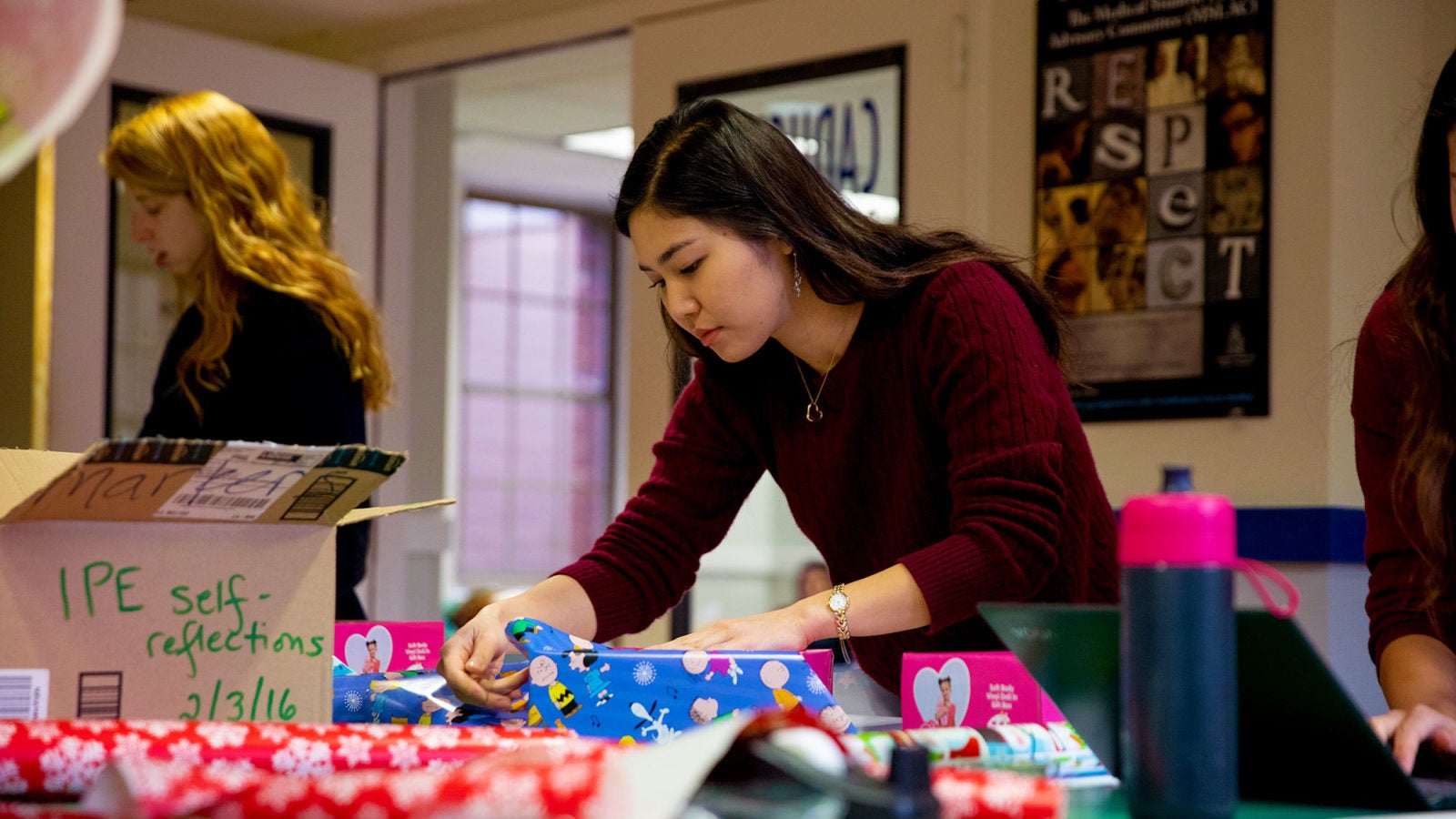 A female student wraps Christmas gifts.