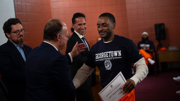 President John J. DeGioia shaking hands with Roy Middletown 