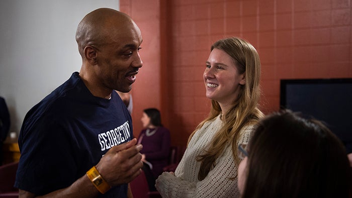 Raymond Dodd wearing a Georgetown T-shirt talks with Georgetown student Frances Trousdale.