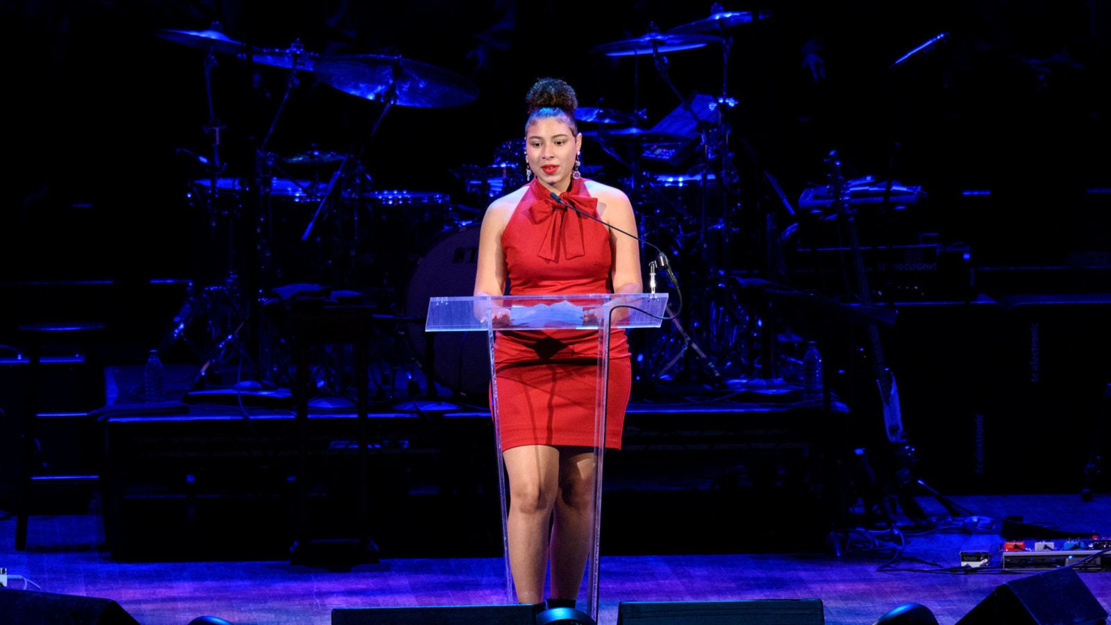 Jordan Brown stands at a lectern on a darkly lit stage.