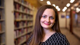 Cassandra Berman next to tall book shelves