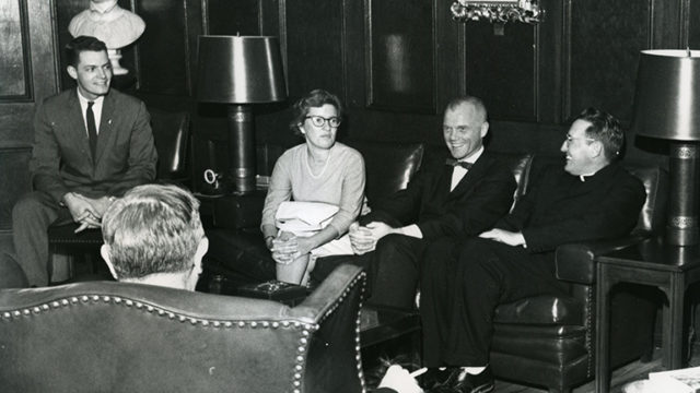 Vera Rubin with John Glenn and other men sitting around in chairs