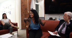 Michelle Renslo, Ehale Izadi and Sanford Ungar sit on sofas laughing