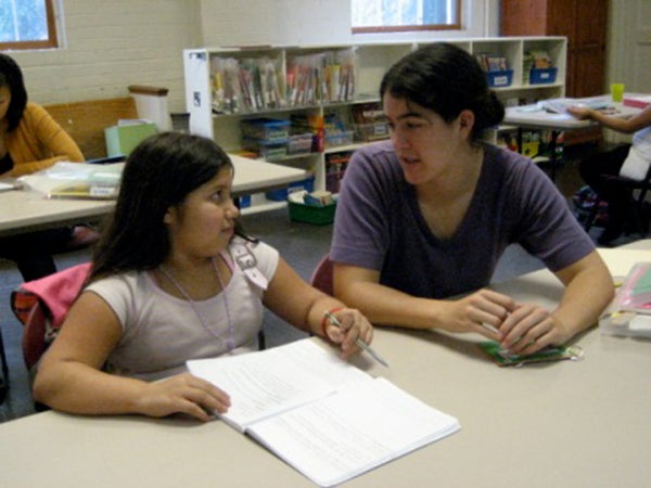 Joanna Foote sits with a child with her notebook open