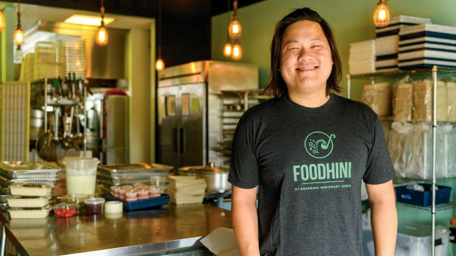 Noobtsaa Philip Vang wearing an apron in his kitchen