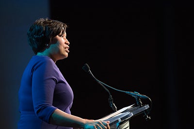 Mayor Muriel Bowser at a podium speaking into a microphone