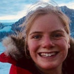 Mia Vanderwilt wearing a parka with snowy mountains behind her
