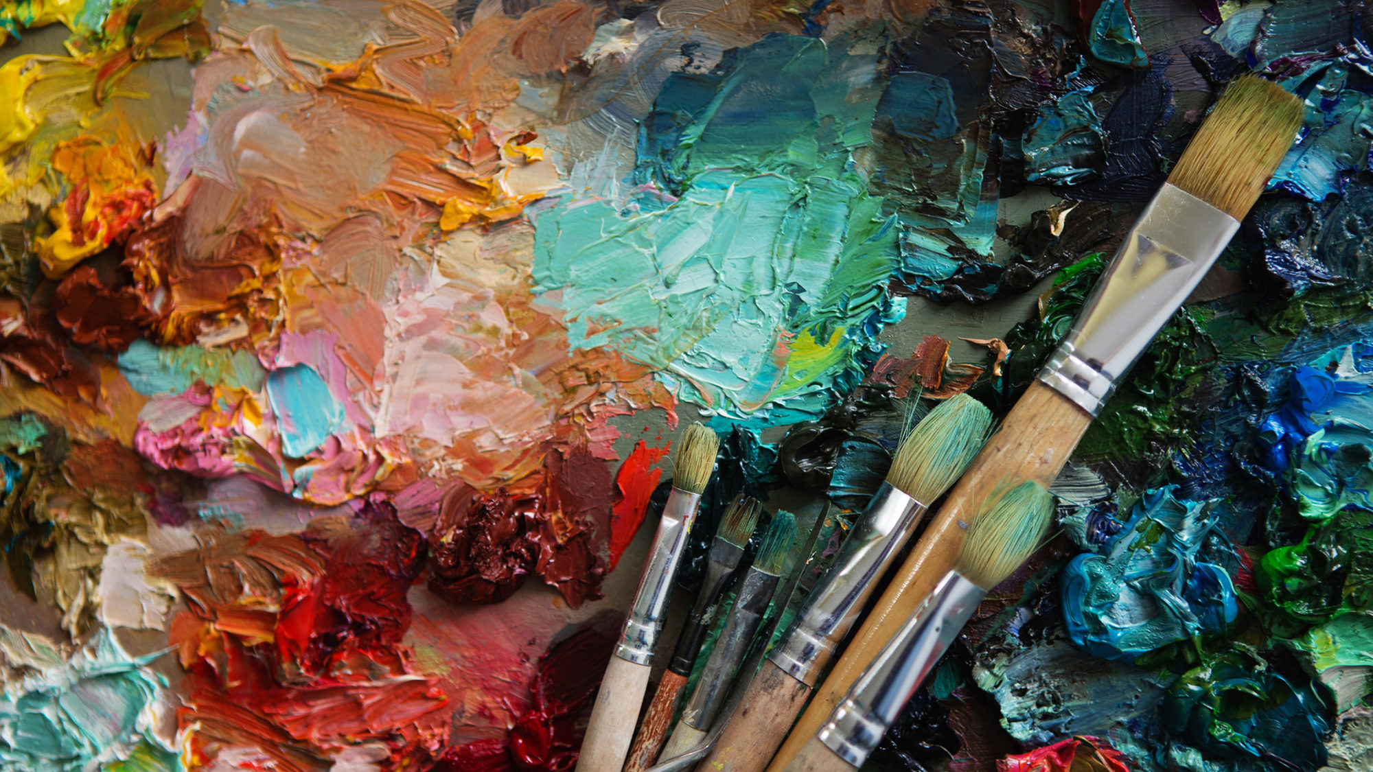 Artists' brushes and oil paints on wooden palette.