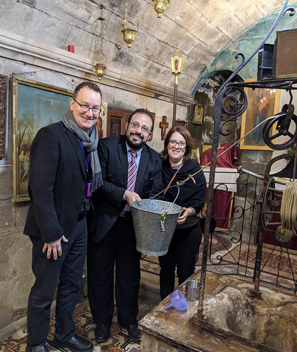 Mark Bosco, Yahya Hendi and Rachel Gartner at Jacob's Well as Hendi and Gartner hold a bucket
