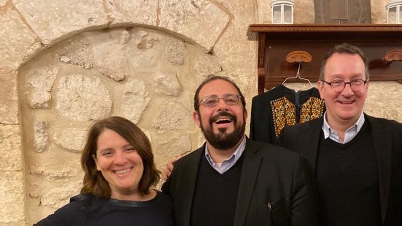 Rachel Gartner, Imam Hendi and Mark Bosco stand in front of a stone archway