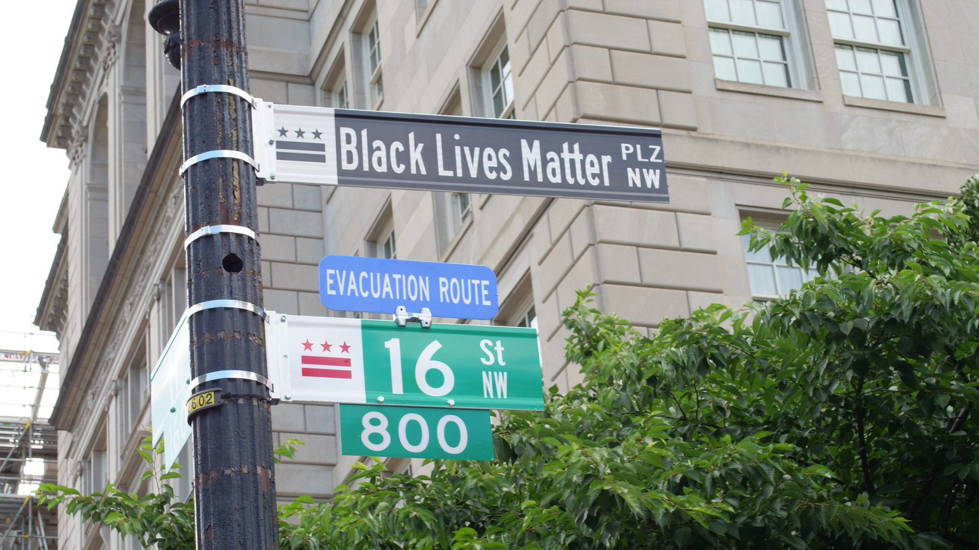 View of a building and street signs that say Black Lives Matter plaza and 16th Street