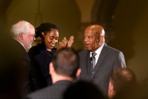 John Carr and Marcia Chatelain stand up as John Lewis joins them on the stage.